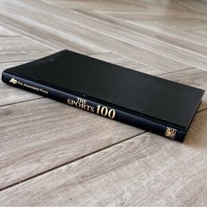 Black Hardcover Book 'The Sports 100'